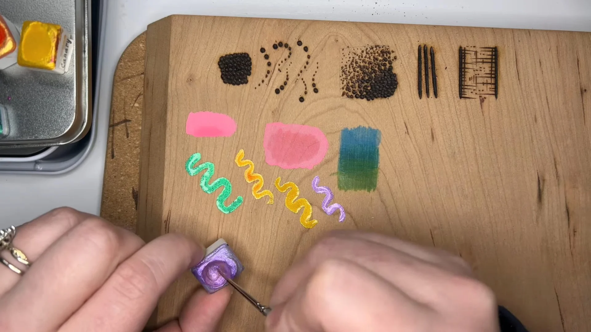 Testing watercolor swatches next to burned textures on wood