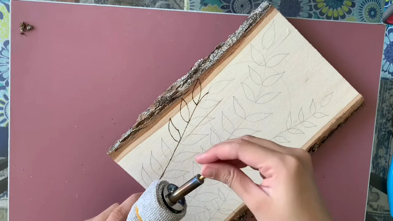 A leaf pattern being burned on wood