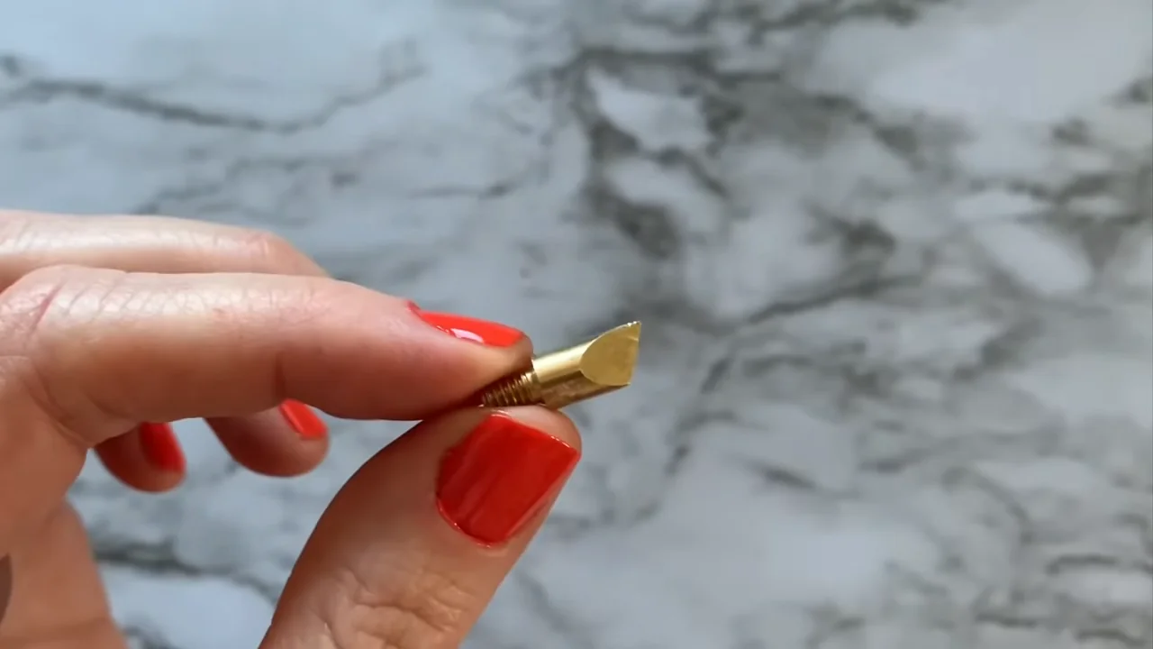 Close-up of a threaded brass universal wood-burning tip with an angled edge