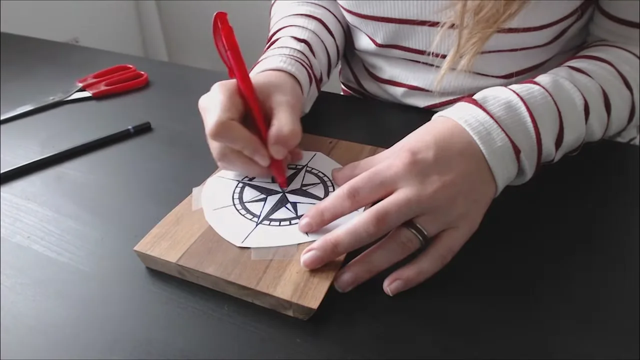 Tracing a printed compass pattern onto wood